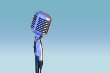 old silver microphone isolated on light blue background