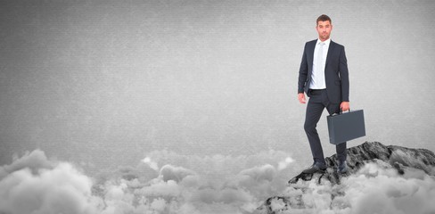 Composite image of businessman standing with his briefcase
