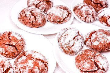 Round cookies stack on a white plate, powder sugar