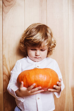 Adorable child posing with pumpkin
