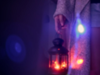 abstract blur : woman hold black lantern with light from candle in the night from christmas celebration event with flare light effect at foreground