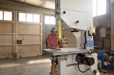 carpenter cutting wood on a band saw