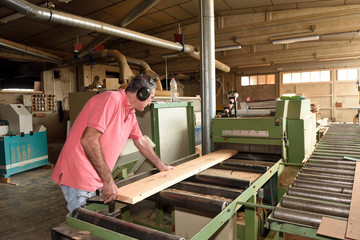 Fototapeta premium carpenter polishing wood in a carpentry workshop