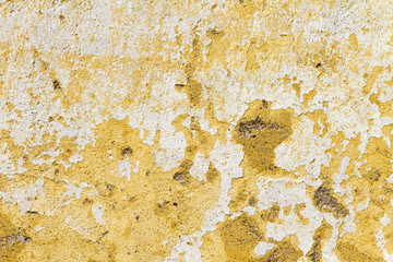 Old and neglected peeled wall with layers of white and yellow paint; Architectural background, texture, pattern; Copy space, sign board.