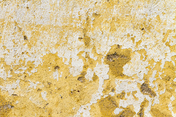 Old and neglected peeled wall with layers of white and yellow paint; Architectural background, texture, pattern; Copy space, sign board.