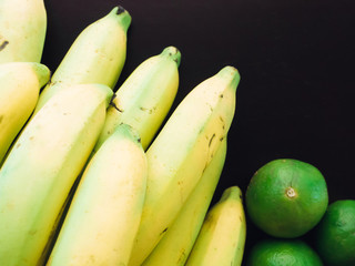 close up top of yellow banana and green lime ingredient of asia healthcare food and juice with wood background