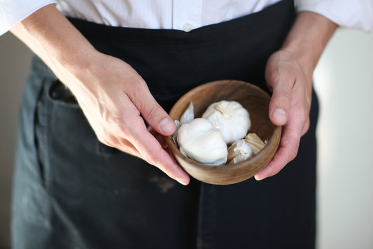 appertising gourmet food close up, chef with garlic in a wooden bowl