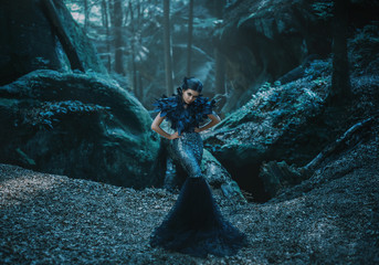 Girl - black raven wanders in the mountains. Gothic photosession theme of Halloween. Unusual, creative outfit