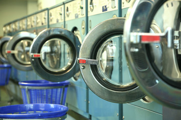 row of empty washing machines in laundromat