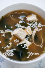 Close-up of miso soup with tofu, wakame and sesame, vertical shot