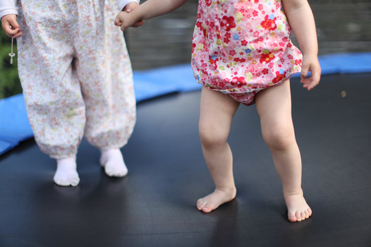 children on trampoline holding hands