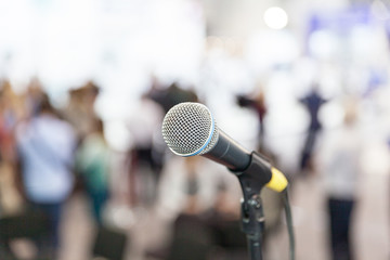 Press conference. Microphone in focus against blurred audience.