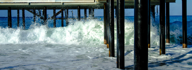 Waves break about the pier pile