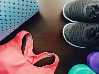 Schilderijen op glas gym workout accessory with pink sportswear , black footwear and yoga mat with soft focus wood background © tickcharoen04
