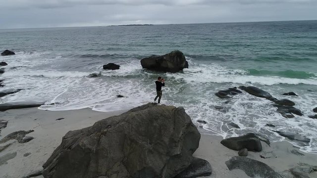 Young boy takes photos on a scenic beach in Norway
