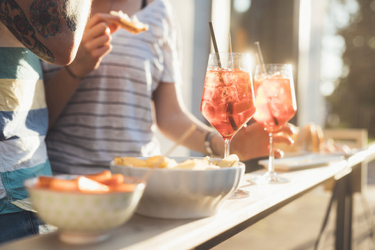 Cropped shot of couple eating tapas at sunlit sidewalk cafe
