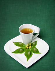 Cup with green tea and green leaves. Tea and candy.