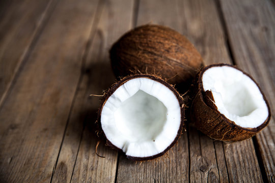 1660274 Ripe half cut coconut on a wooden background. Ripe half cut coconut on a wooden background. Coconut cream and oil.