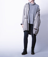 Woman wearing casual outfit with oversized parka jacket, grey knitted turtleneck sweater, black...