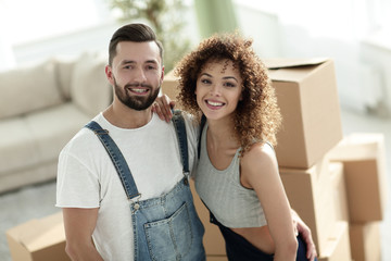 Happy married couple on the background of a new apartment