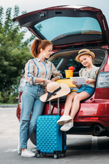 mother and daughter in car trunk