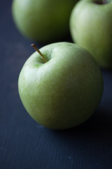 Green apples on a black background