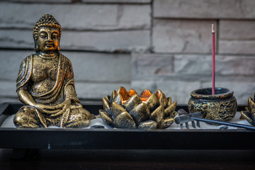 Mini, desk zen garden with lit candle and small Buddha in it