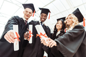 multiethnic students showing diplomas