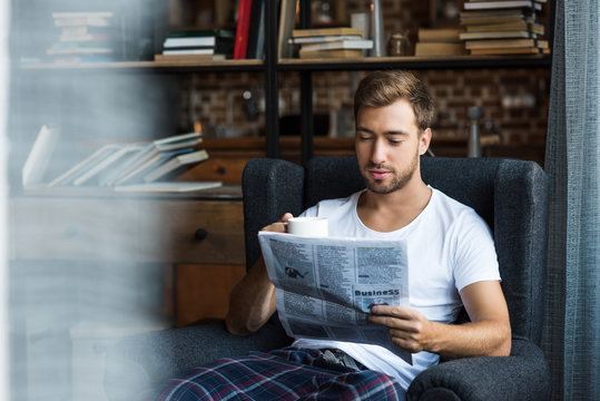 Man Reading Newspaper At Home