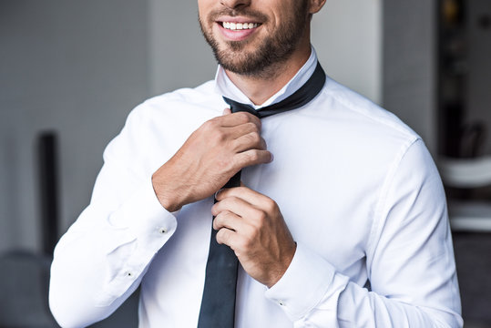 Businessman Putting On Tie