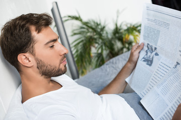 Obraz premium Man in bed reading newspaper