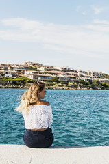 Young tourist woman looking on the sea, back view