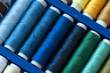 Close-up on colored sewing threads on spools