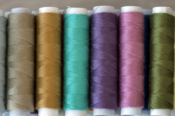 Close-up on colored sewing threads on spools