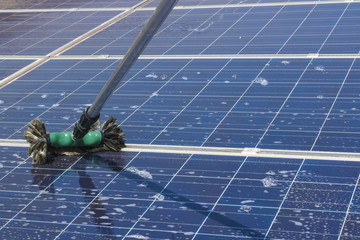 Cleaning solar panels on house roof - Solar Energy Concept Image