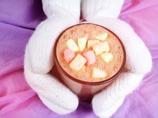 Soft photo of woman on the bed with notebook, cup of coffee, top view point.Female legs in warm woolen socks.