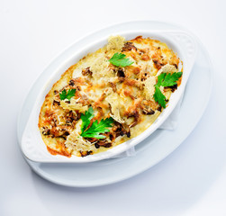 Tasting and appetizing traditional Italian lasagna dish with mushrooms served with fresh dill in a white plate Autumn menu in an Italian restaurant. Hotel service photo background