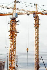 Large construction crane builds a house