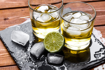 glass of whiskey on wooden background