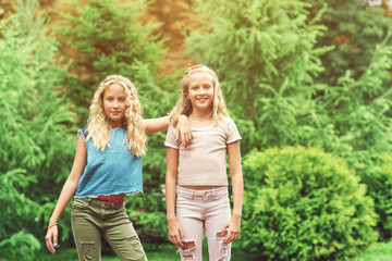 Fototapeta premium Portrait of beautiful teenager girls twins at park.