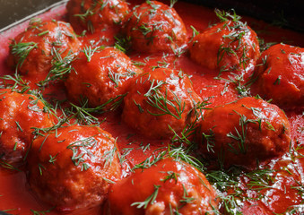 Meatballs with spicy tomato sauce in pan. on wooden background