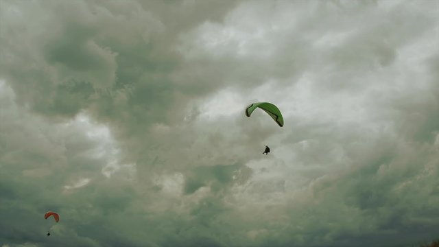 paragliders against the background of clouds in the sky