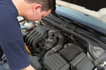 Man examining under hood of car
