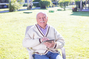 Fototapeta premium Elderly man using tablet outdoor