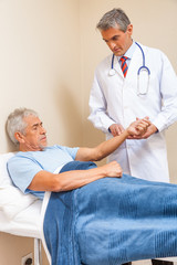 Fototapeta premium Doctor analyzing elderly male patient in hospital