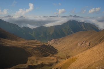 landscape mountain valley and green mountain peaks with clouds in the distance