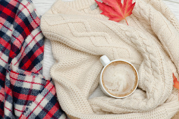Cappuccino, milk knitted sweater. checkered plaid and autumn leaves. Fashionable concept