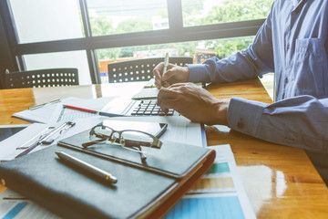 Businessman using a calculator to calculate numbers