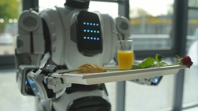 Scaled up look on robot holding trey with breakfast