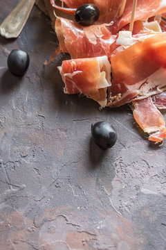 Portion of Ib&eacute;ric ham, along with bread and olives.